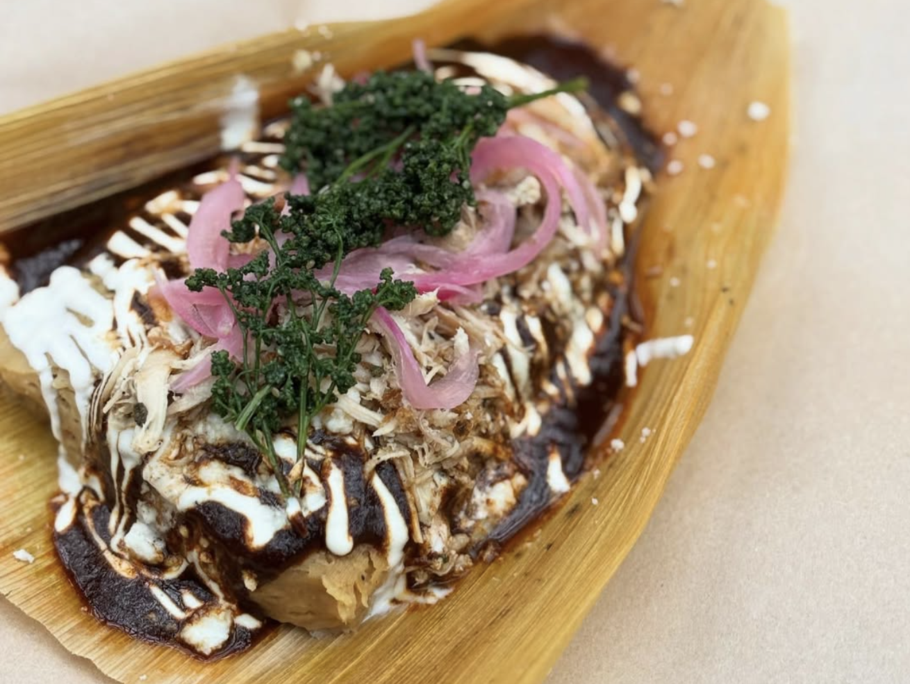 a tamal with homemade mole, turkey, and huauzontle
