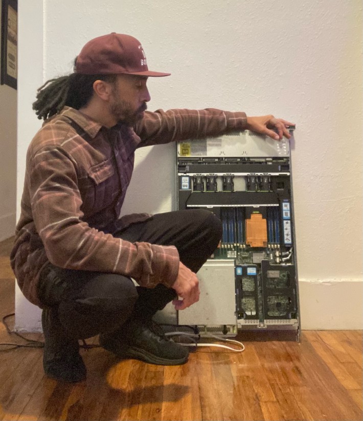 a man squats next to an online server