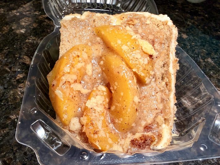 peach cobbler cake inside a plastic to-go container