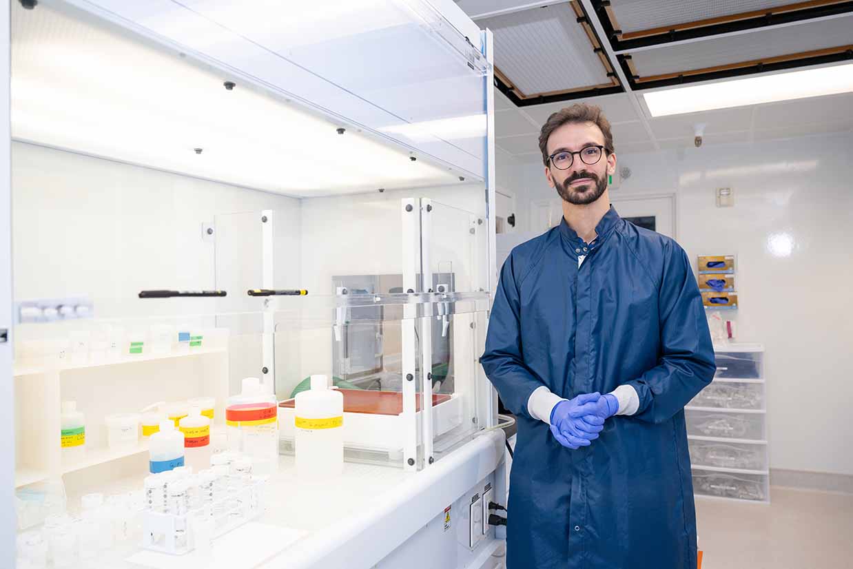 a portrait of scientist Francois Tissot in his CalTech lab, next to some vials of liquid and science equipment