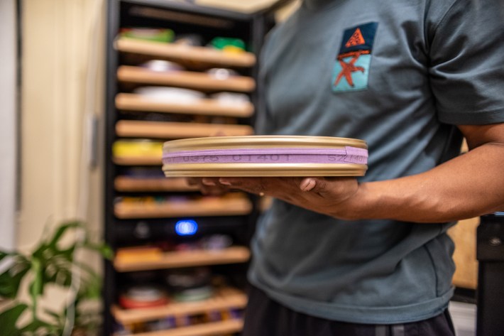 a man holds a reel of cinema film
