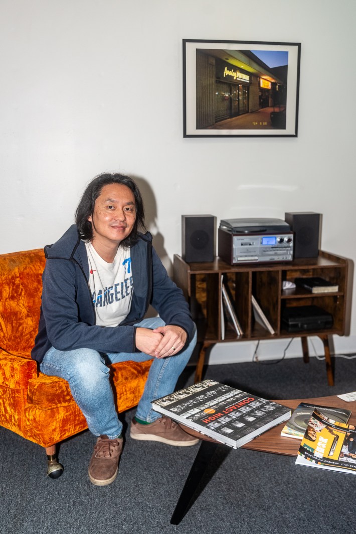 a man smiles from an orange chair