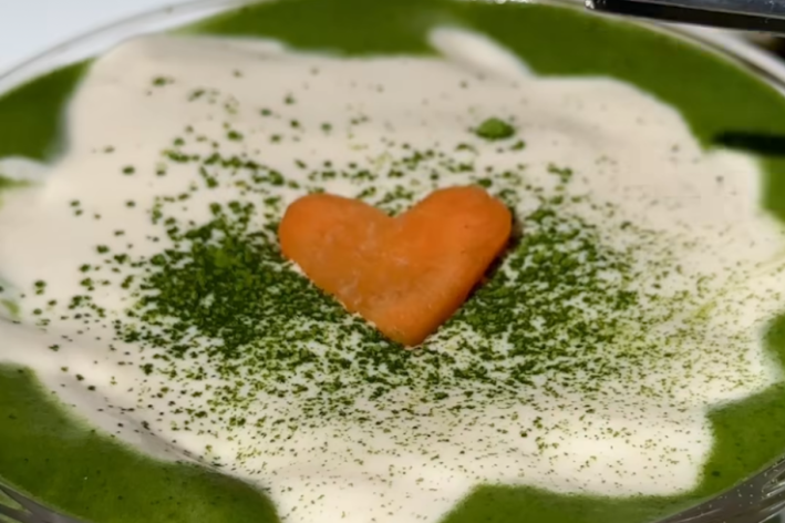 a match latte with an orange heart on top