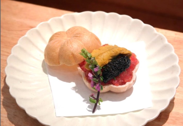 Tuna, uni, and caviar in a crisp monaka shell with an edible flower laid on top