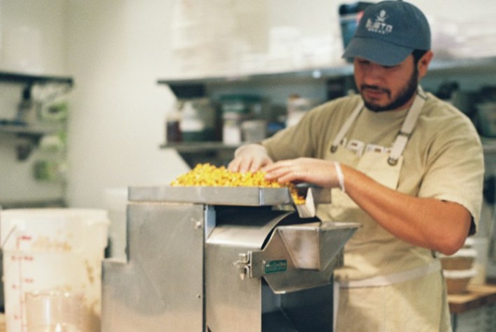 Arturo Enciso grinding fresh nixtamal at Gusto Bread in Long Beach.