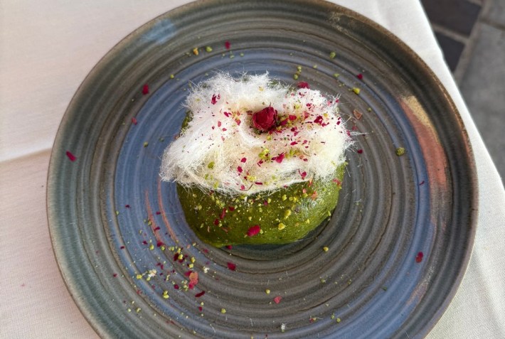 a green dessert with white, fluffy garnish on top
