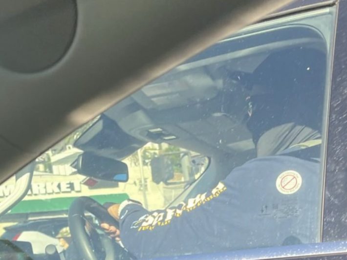 the shot of a masked agent inside a car