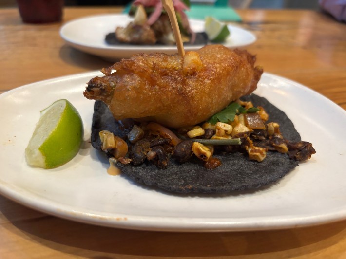 a blue corn tortilla with a fried squash blossom on top