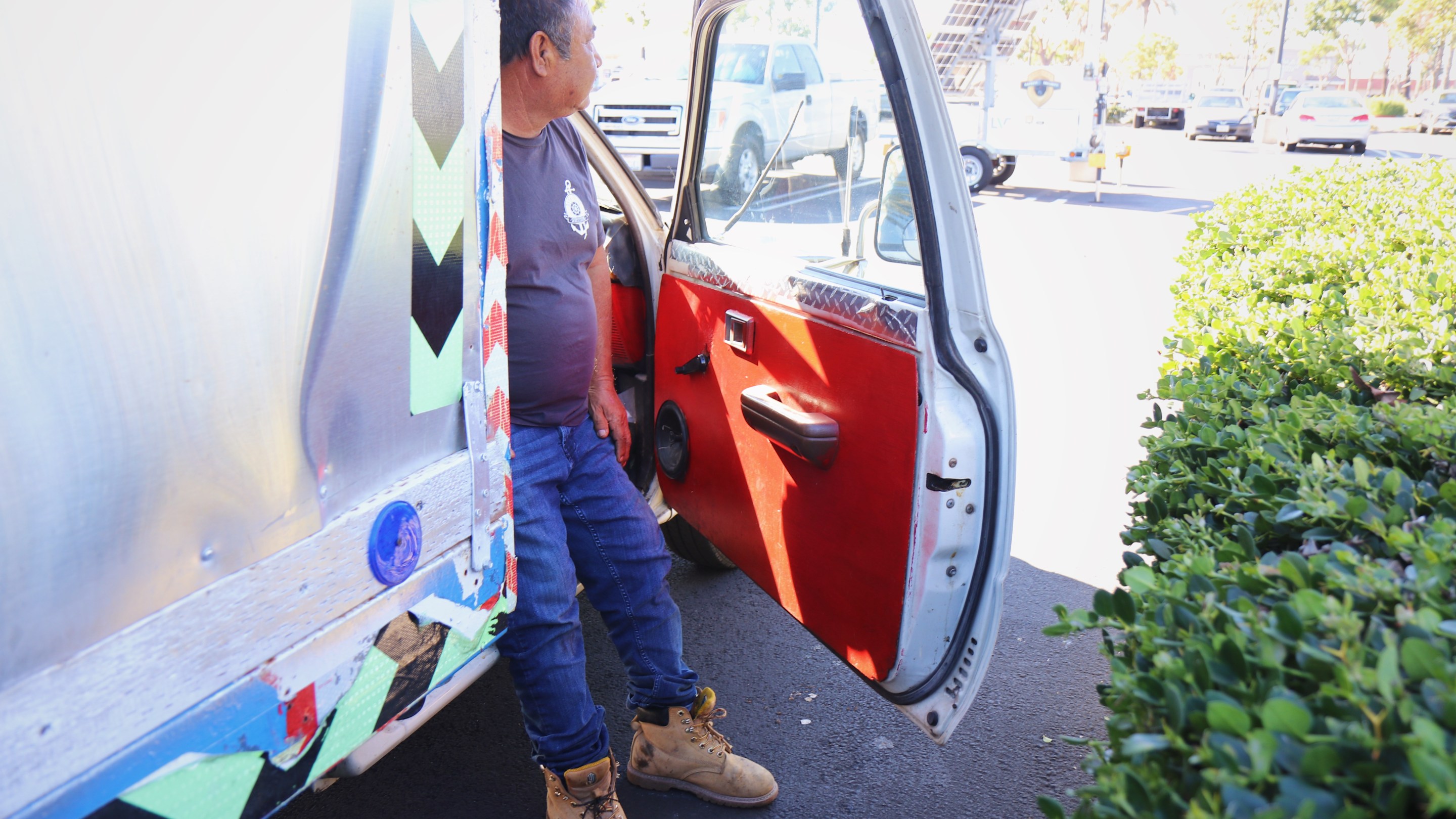 a man stands outside of his truck