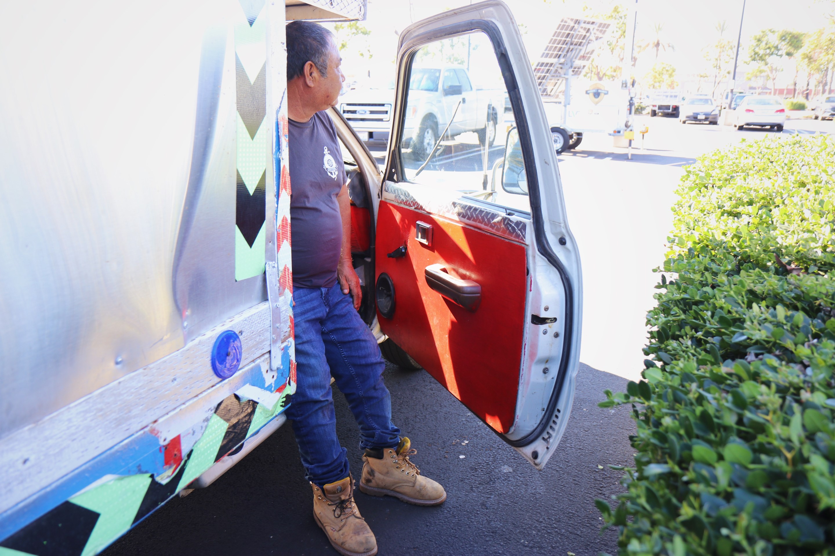 a man stands outside of his truck