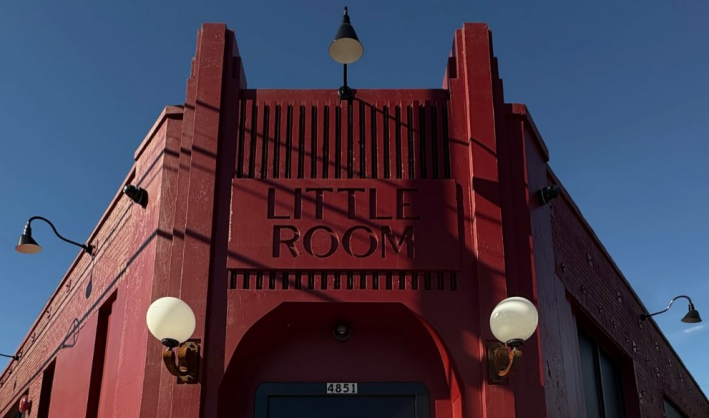 A red building with the words Little Room engraved on the frieze