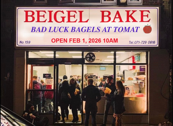 a shot of people gathered outside a restaurant that says Bagel Bake Bad Luck Bagels at Tomat
