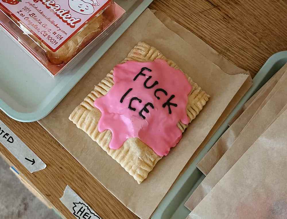 a Pop_Tart that says FUCK ICE in black icing on top of pink icing