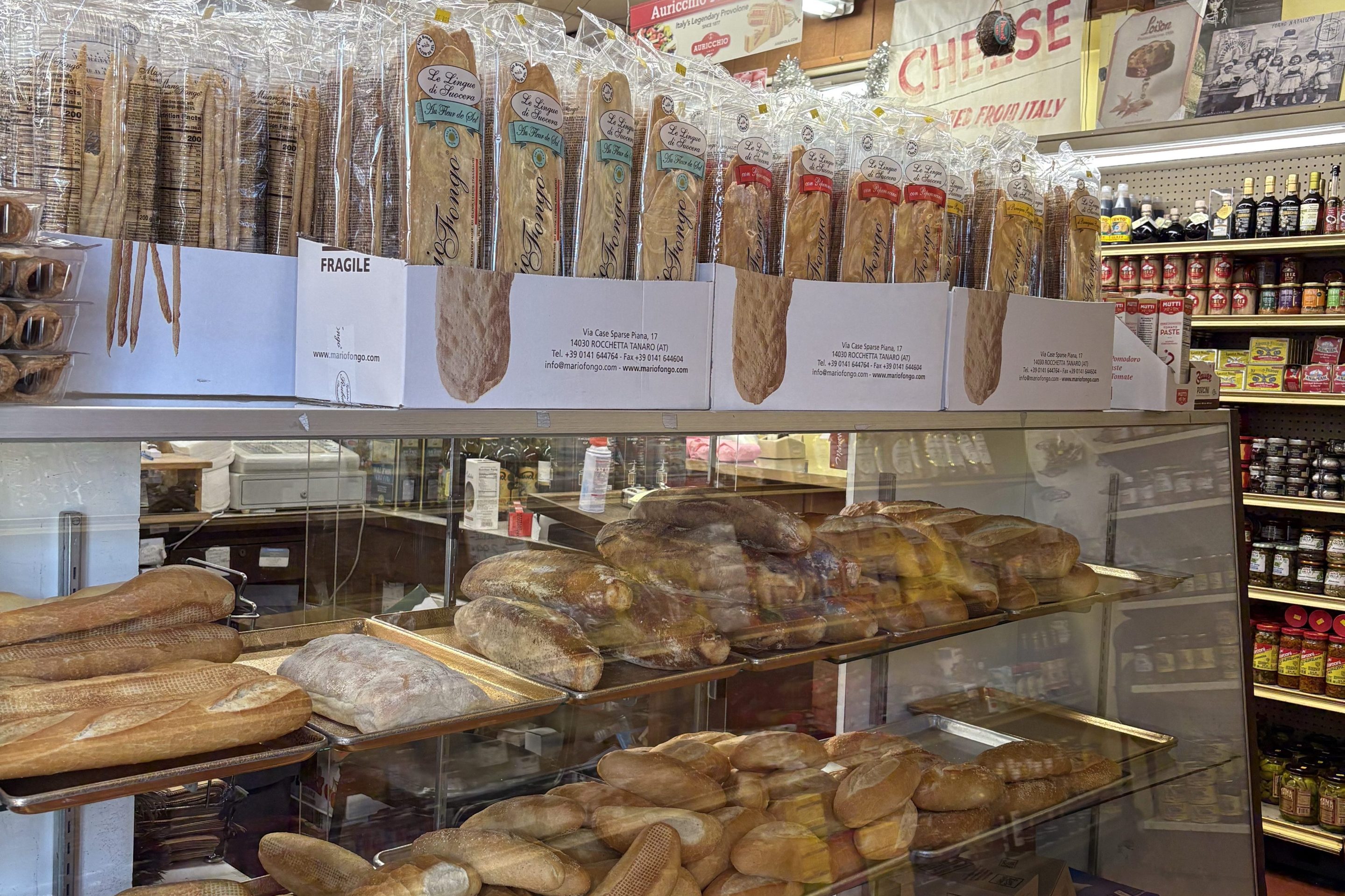 A glass display containing loaves of bread in a deli