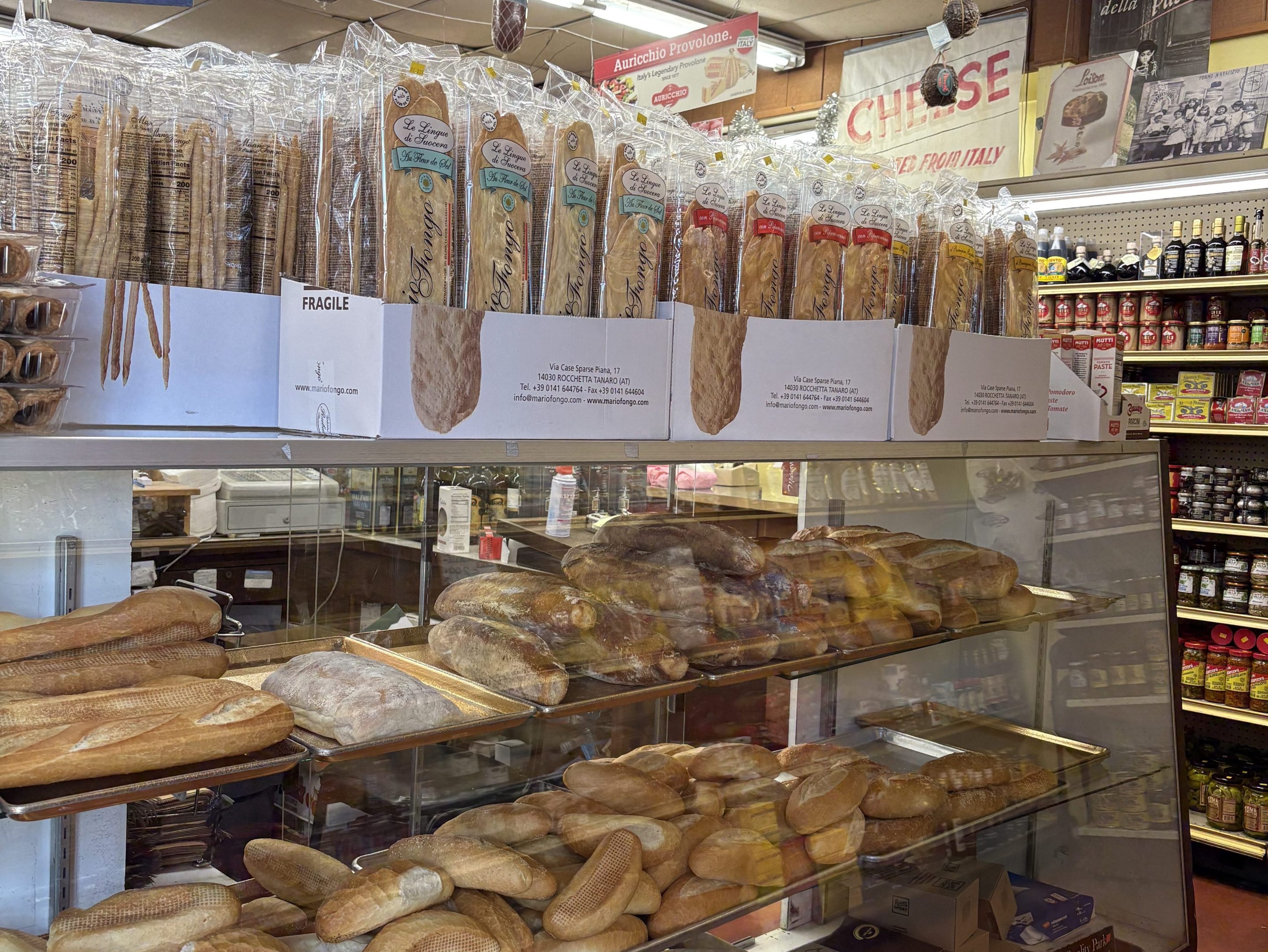 A glass display containing loaves of bread in a deli
