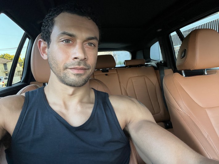 a man poses inside a car