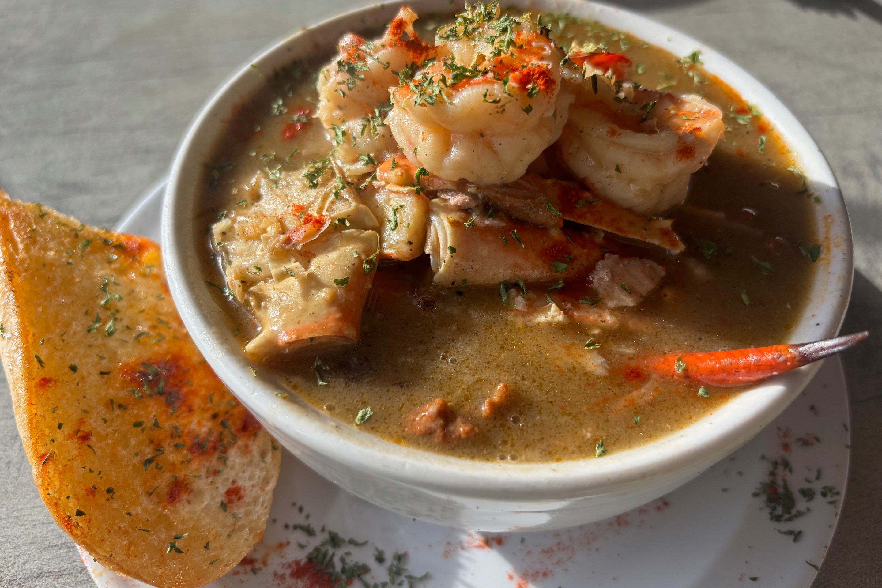 a bowl of gumbo with shrimp and crab sticking out