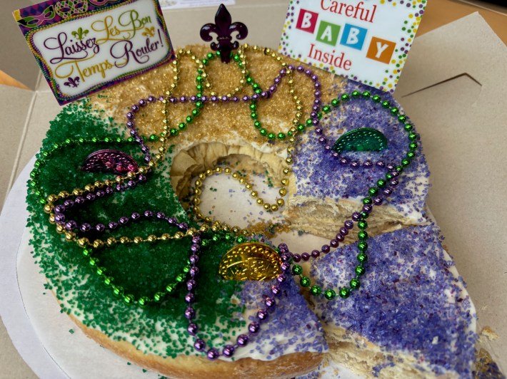 a king cake with beads and little signs