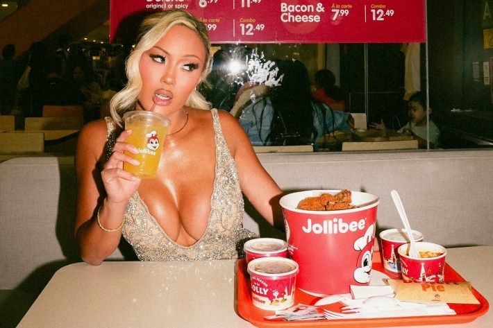 a woman in front of a bucket of Jollibee fried chicken