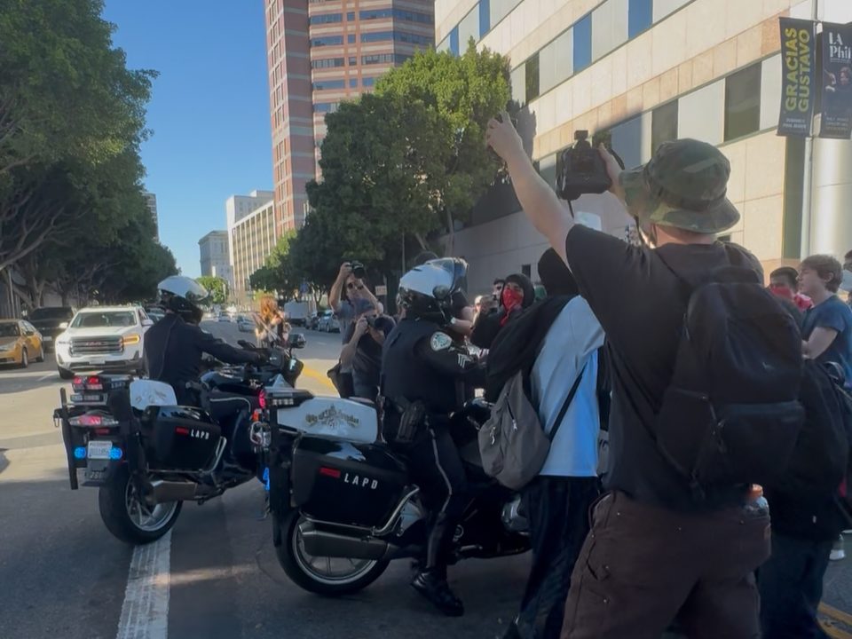 protestors by two cops on motorcycles