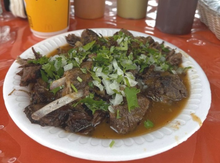 Birria de chivo en consome with goat rubs sticking out