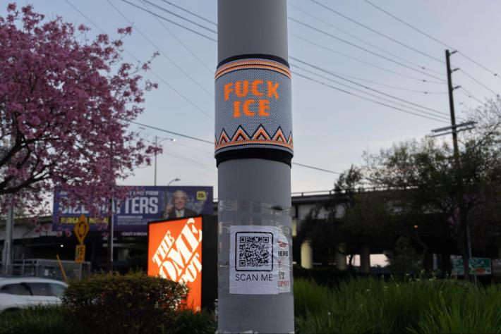 "FUCK ICE" bead art on a street pole
