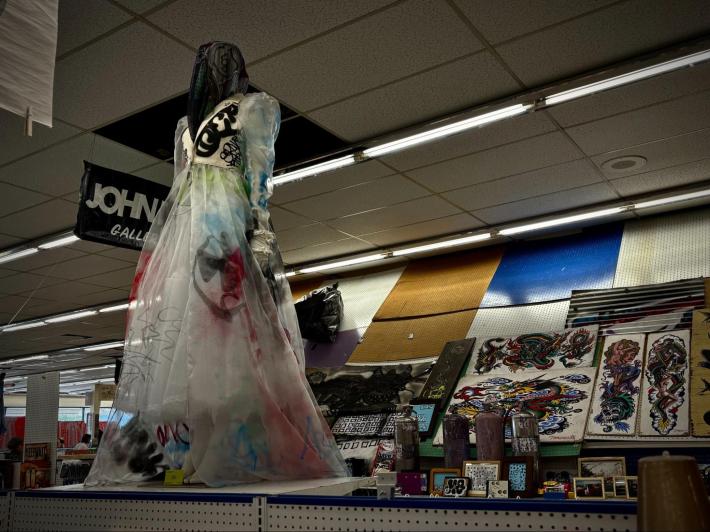 a mannequin wearing a wedding dress painted in graffiti
