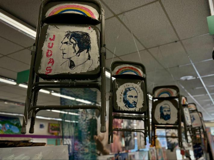 painted metal folding chairs hanging from the ceiling