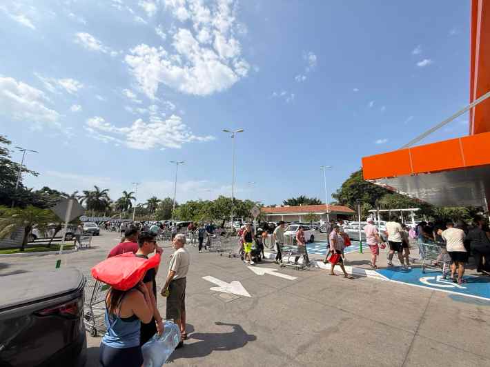 a line of people waiting for a grocery store