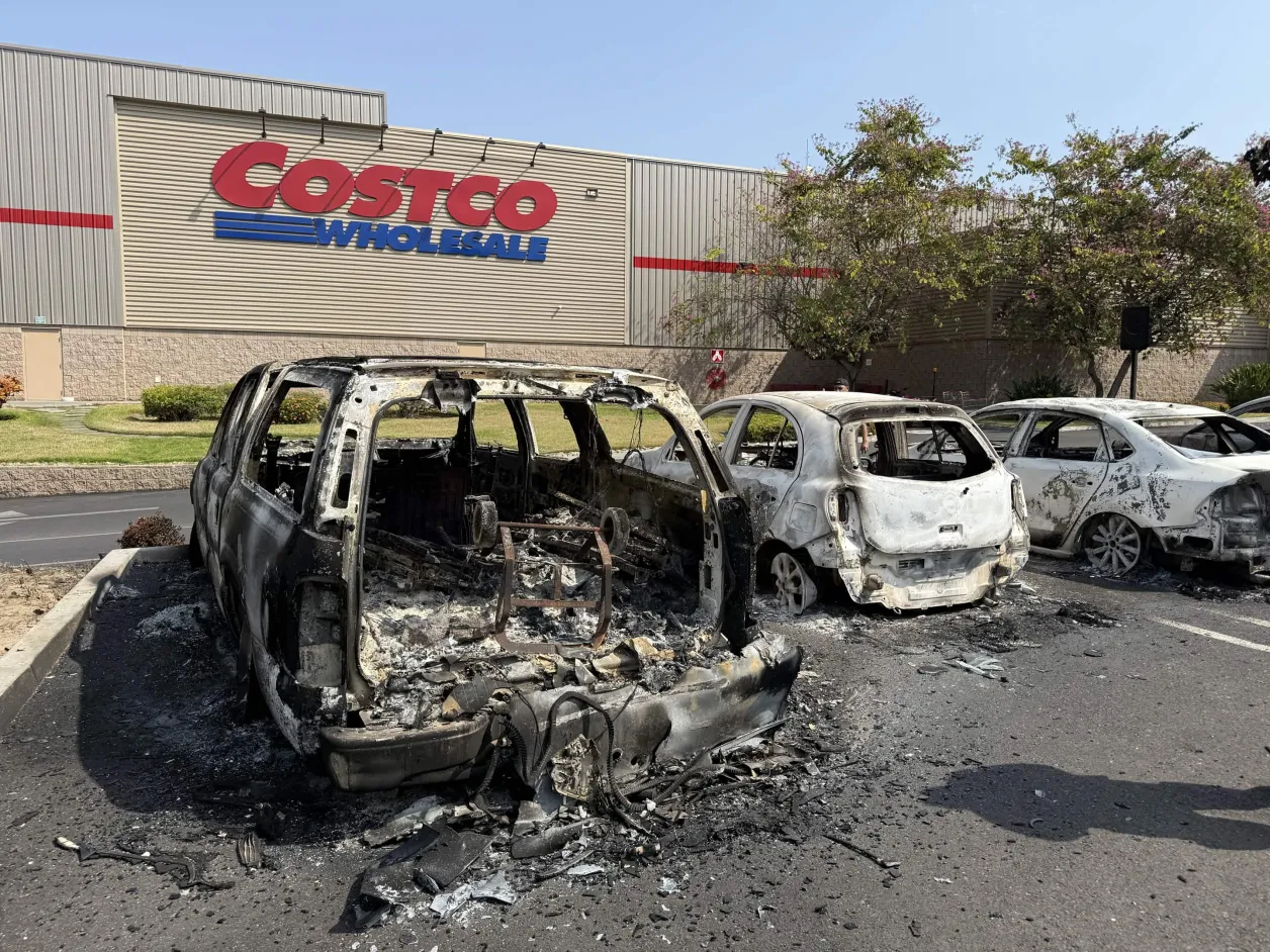 a burnt car next to a Costco