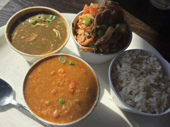 two bowls of soups, one bowl of a rice dish, and one bowl of plain rice