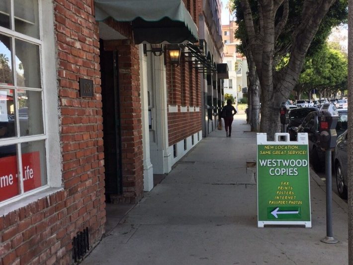 "westwood copies" sign on a sidewalk