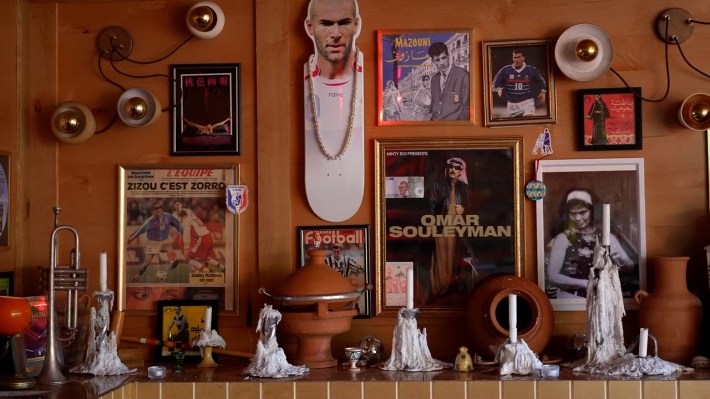 framed artwork of musicians and athletes behind candles