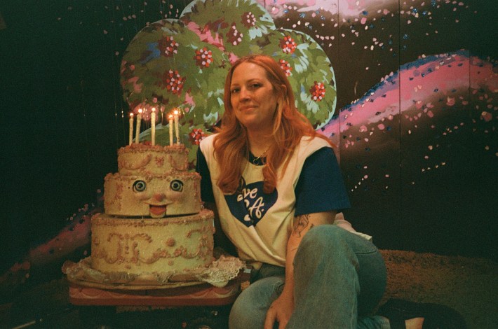 a woman next to a puppet birth day cake