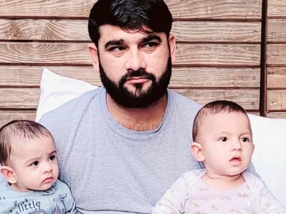 a man poses with two of his children