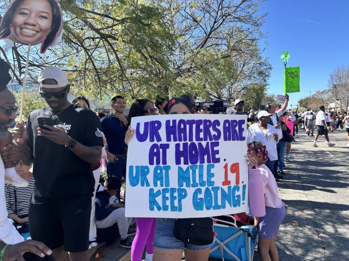 a sign saying "Ur haters are at home. Ur at mile 19. Keep going!"