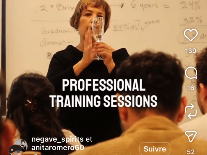 a woman at the front of a class holding a glass