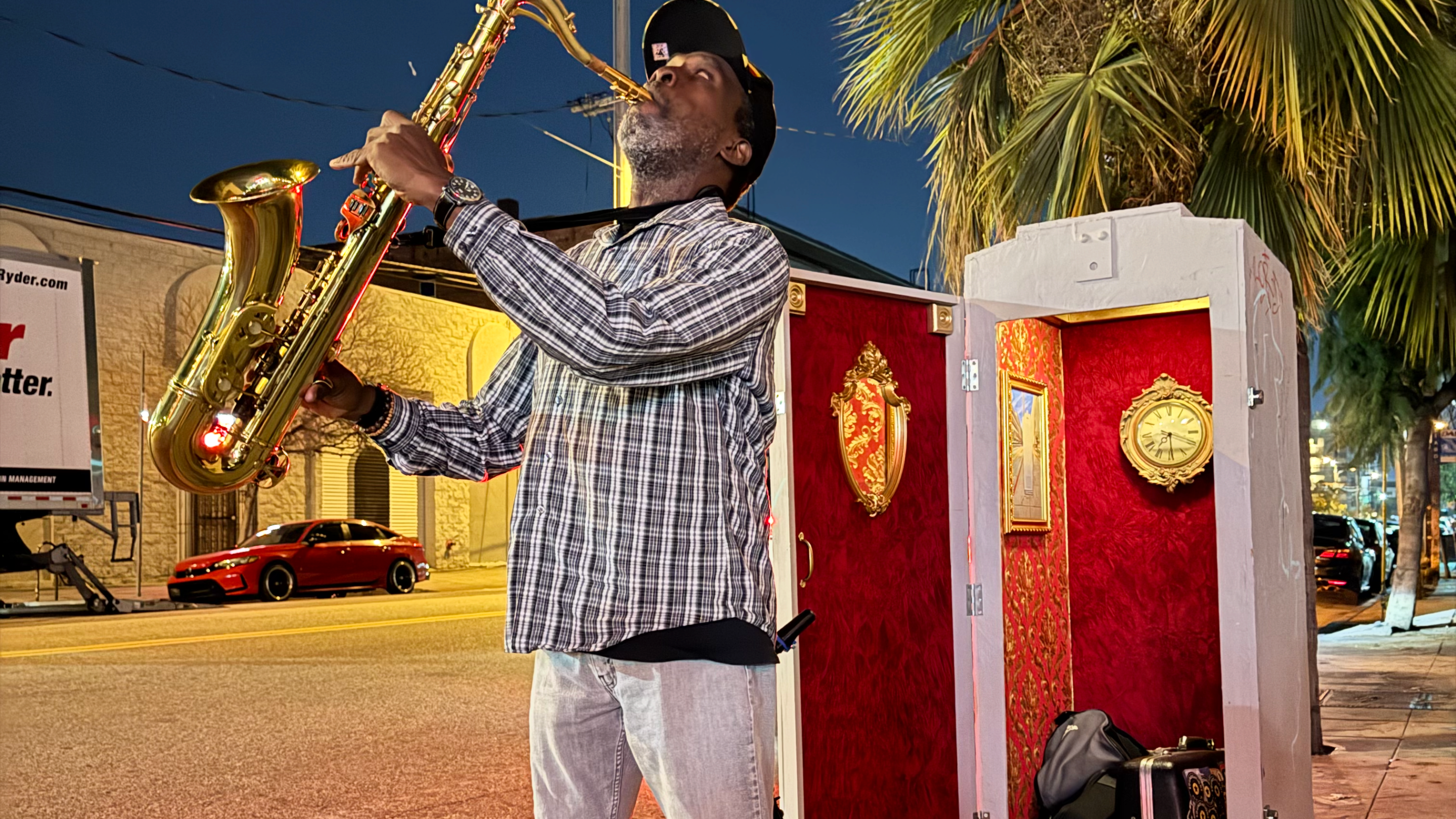 a man plays the saxophone in front of an electrical box theater