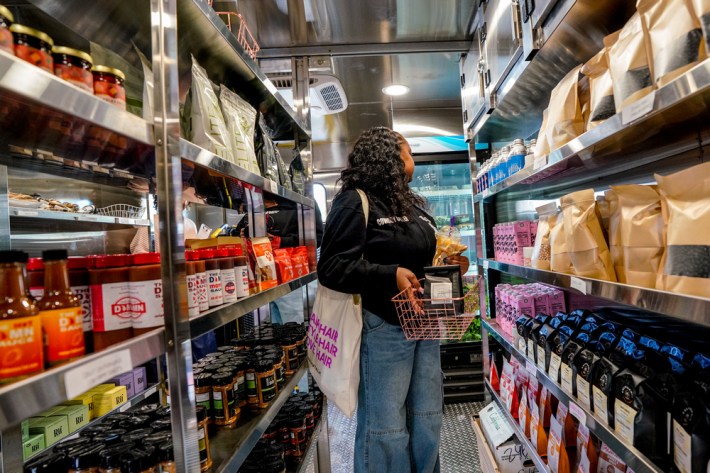 A woman shops the shelves of a market in a 48-foot trailer