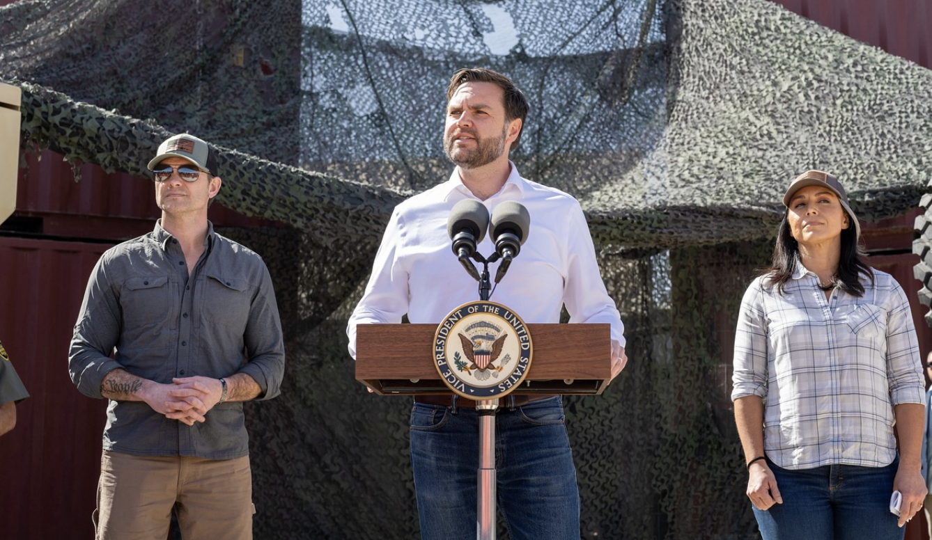 two men and a woman onstage at a press conference
