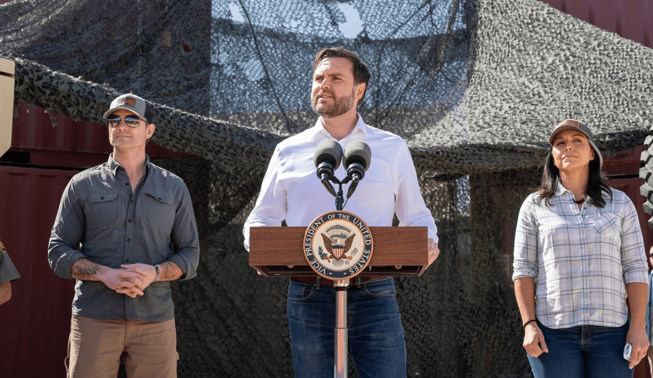 two men and a woman onstage at a press conference