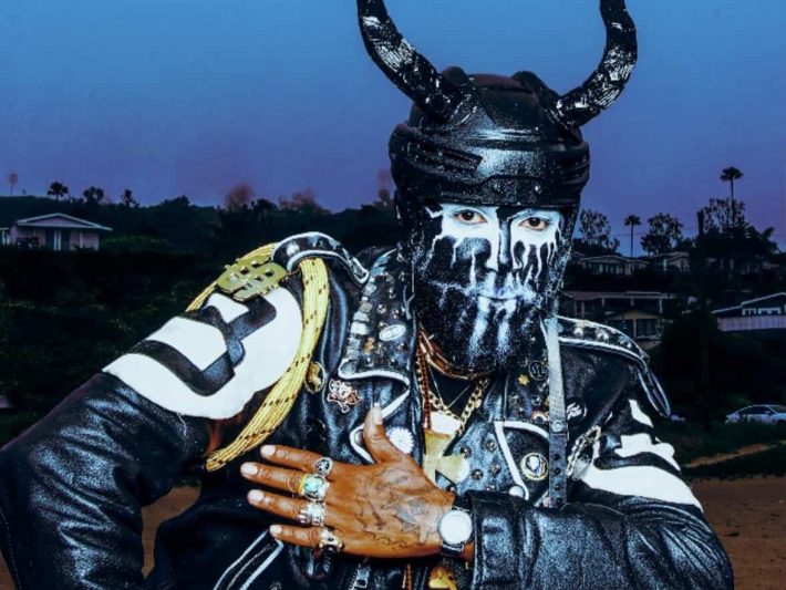 a person poses in a mask with horns