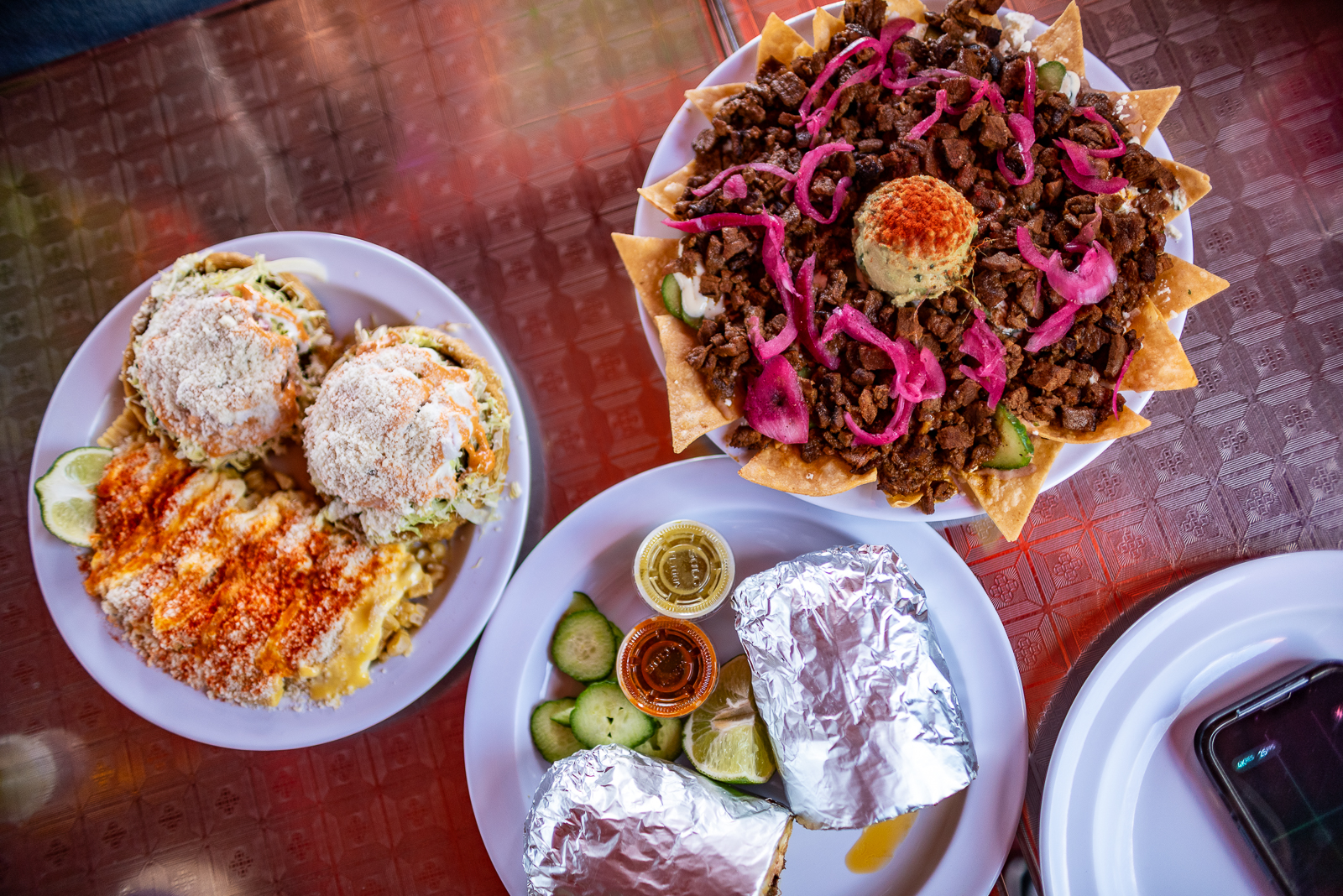plates of sopes, nachos, and burritos