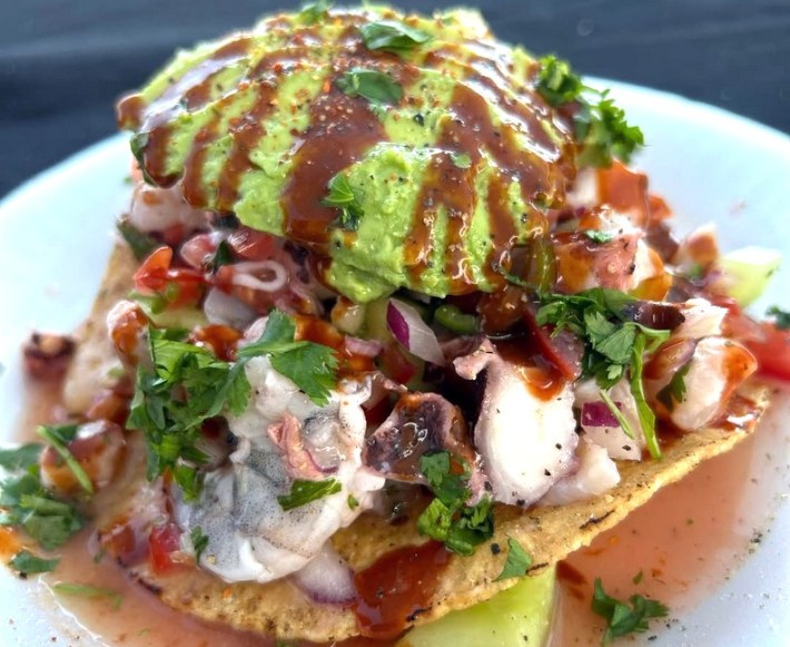 Pulpo and camaron tostada topped with avocado, cilantro, and salsa roja