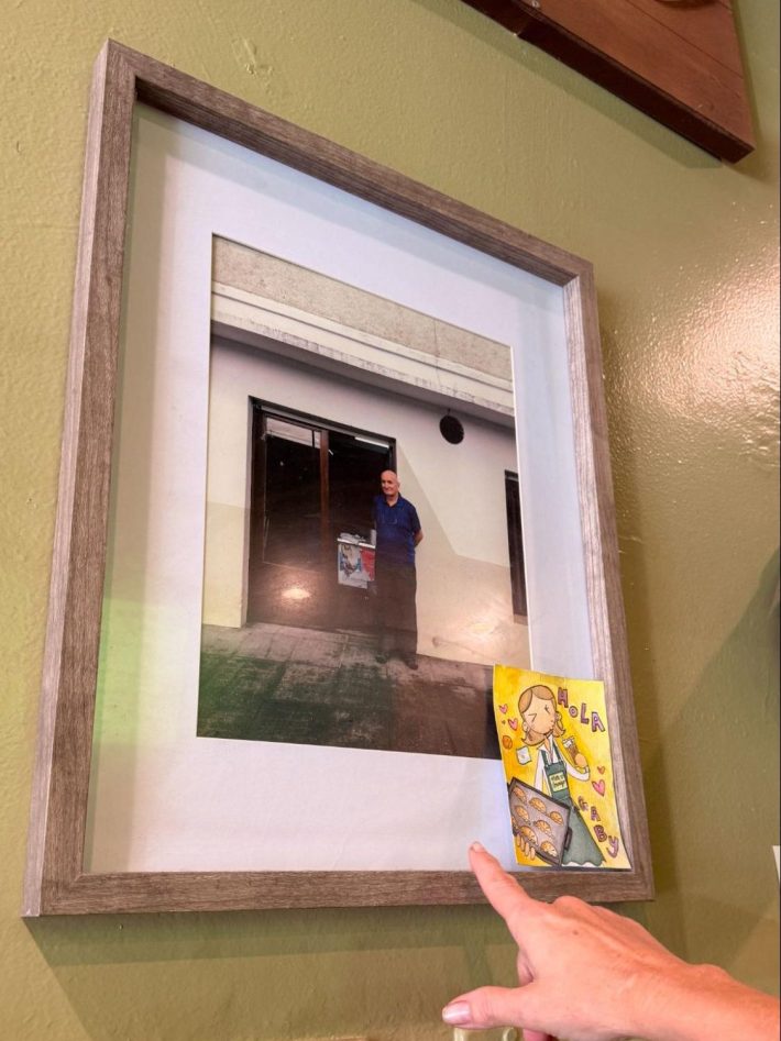 a woman pointing to a photo of her father