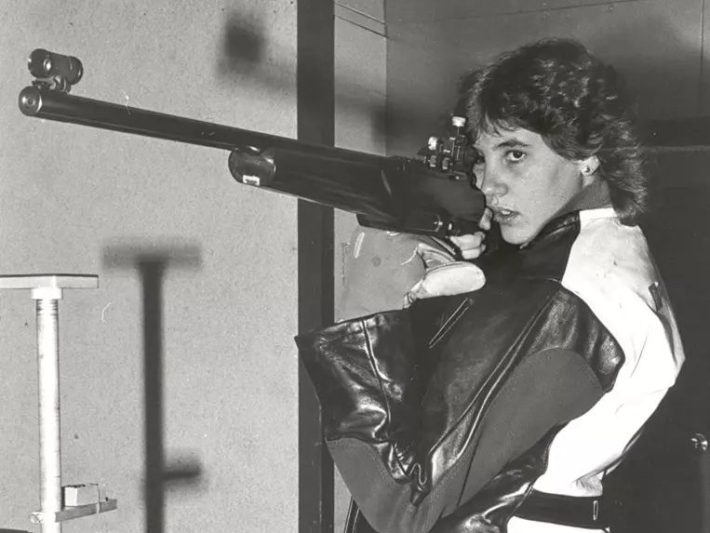 a woman aims an air rifle