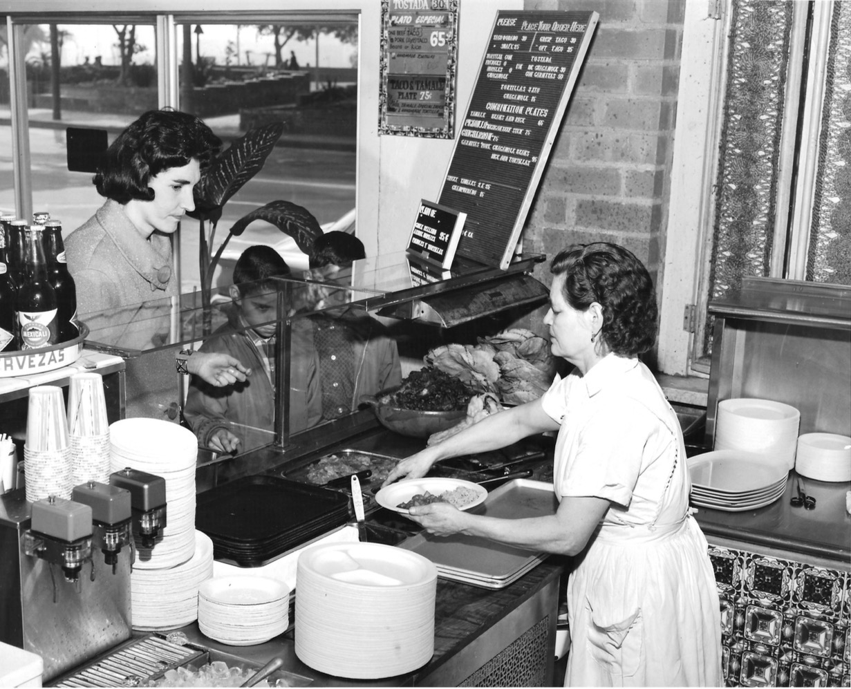 a woman in a restaurant prepares a plate of food