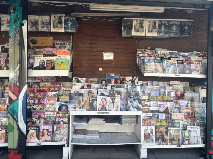 an outdoor newsstand with many magazines on display