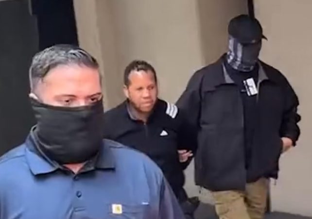 a man is detained by two agents