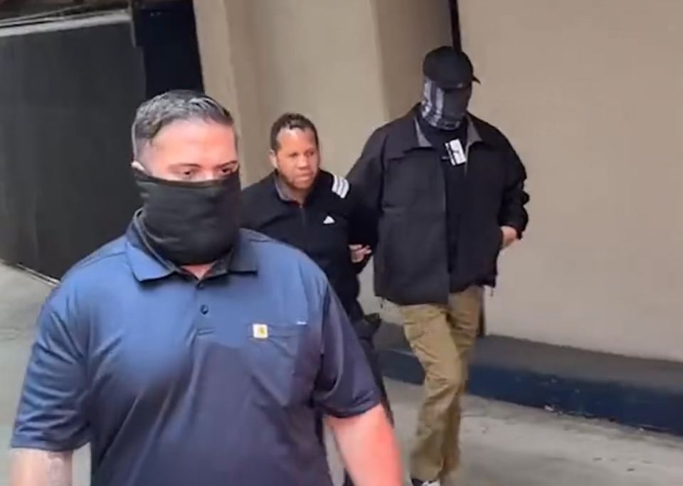 a man is detained by two agents